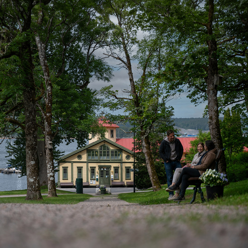 Tre personer samtalar på en bänk vid Gustafsberg i Uddevalla